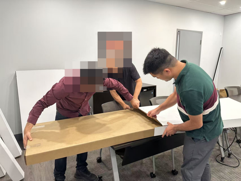 双方围绕纸盒样品查看边缘结构并沟通尺寸